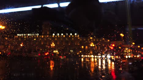 luces desenfocadas en la calle de la ciudad nocturna mientras llueve