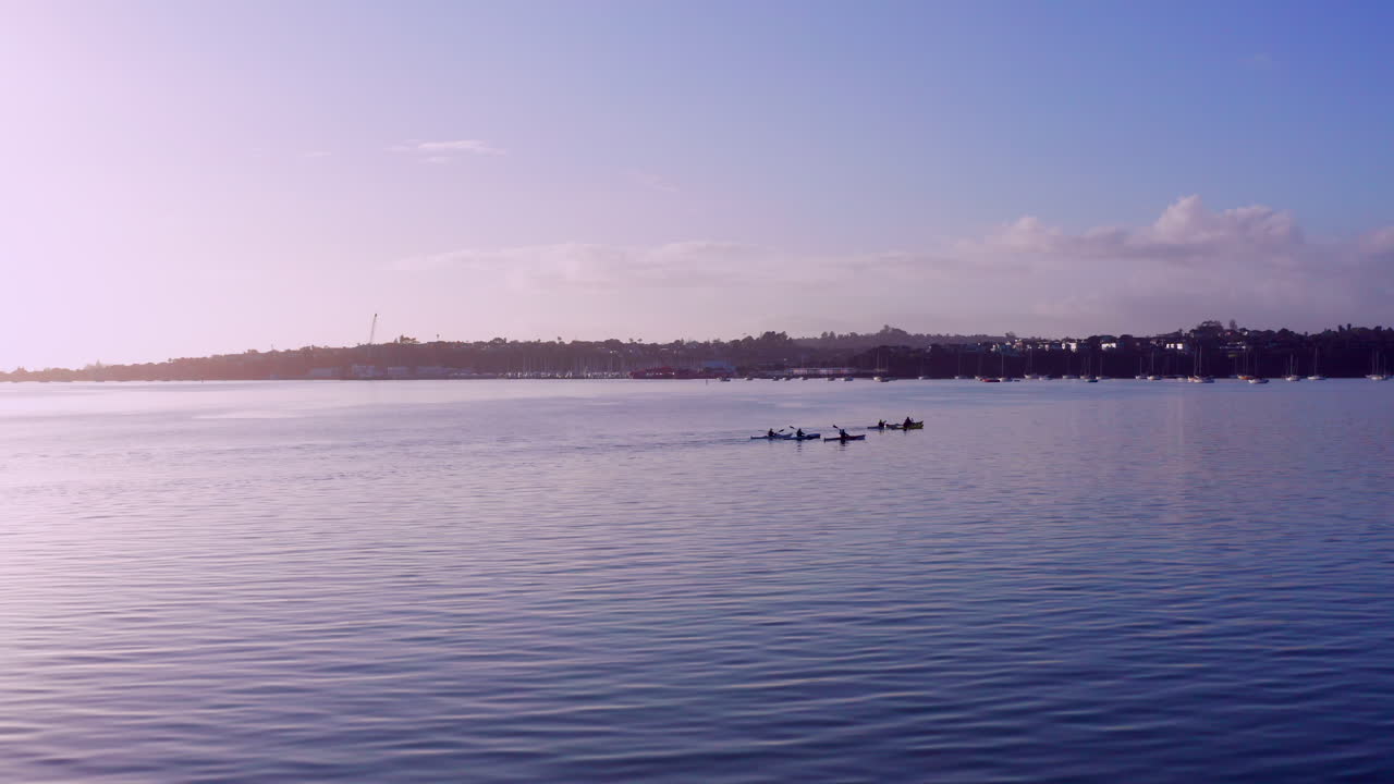grupo de personas en kayak en una playa tranquila en nueva zelanda