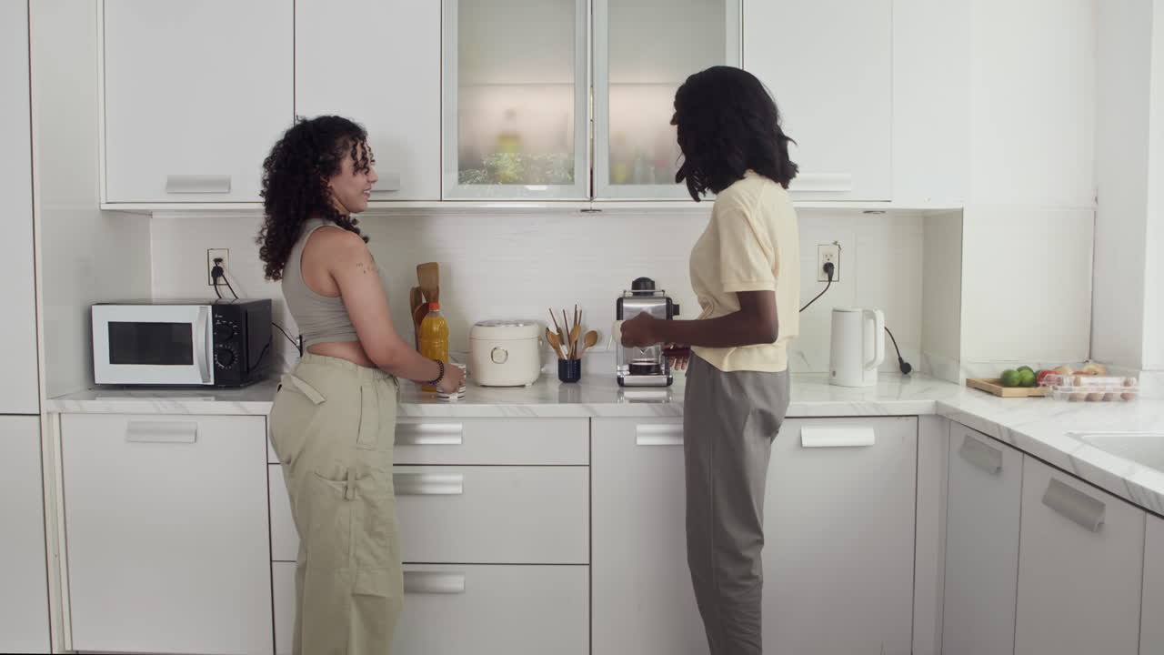 Giovani donne che parlano in cucina
