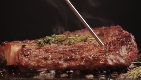 cooking a steak with a thermometer