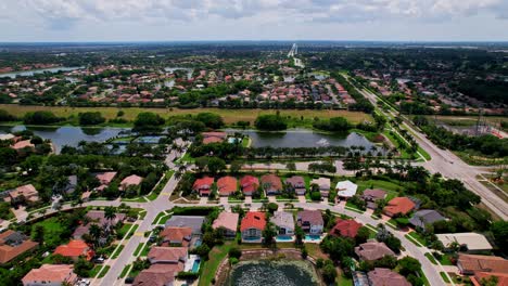 push in drone shot of residential area, lake and mansions during the day in boca raton, west palm beach, florida, usa