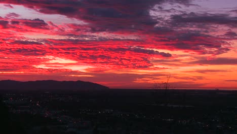 Ein-Strahlend-Roter-Sonnenuntergang-Mit-Funkelnden-Lichtern-Der-Stadt