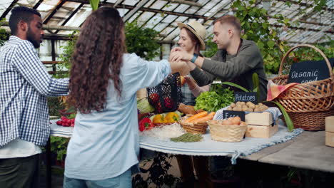 people shopping at a farmers market greenhouse