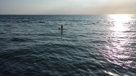 Paddleboarder-Y-Un-Surfista-Disfrutando-De-Las-Tranquilas-Aguas-Alrededor-De-La-Isla-De-La-Reunión-Mientras-Se-Pone-El-Sol