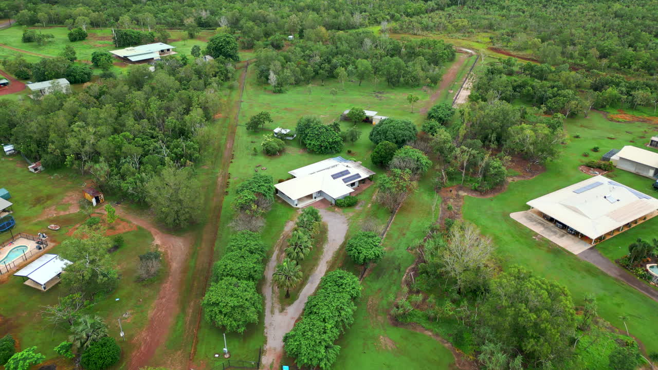 Aerial Drone of Rural Estate Huge Block Of Land With Tropical Luxury Home and Large Outdoor Shed at End of Gravel Roundabout Driveway