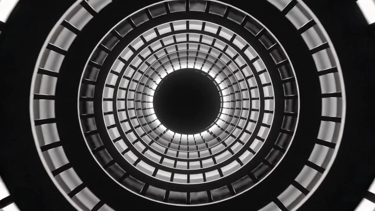 Rivelando un atrio circolare dal basso che mostra balconi concentrici, con le ringhiere che si attenuano come un diaframma.