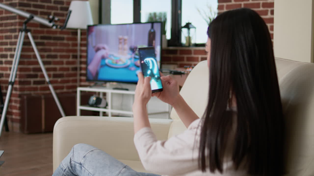 거실에서 스마트 폰을 사용하는 여성