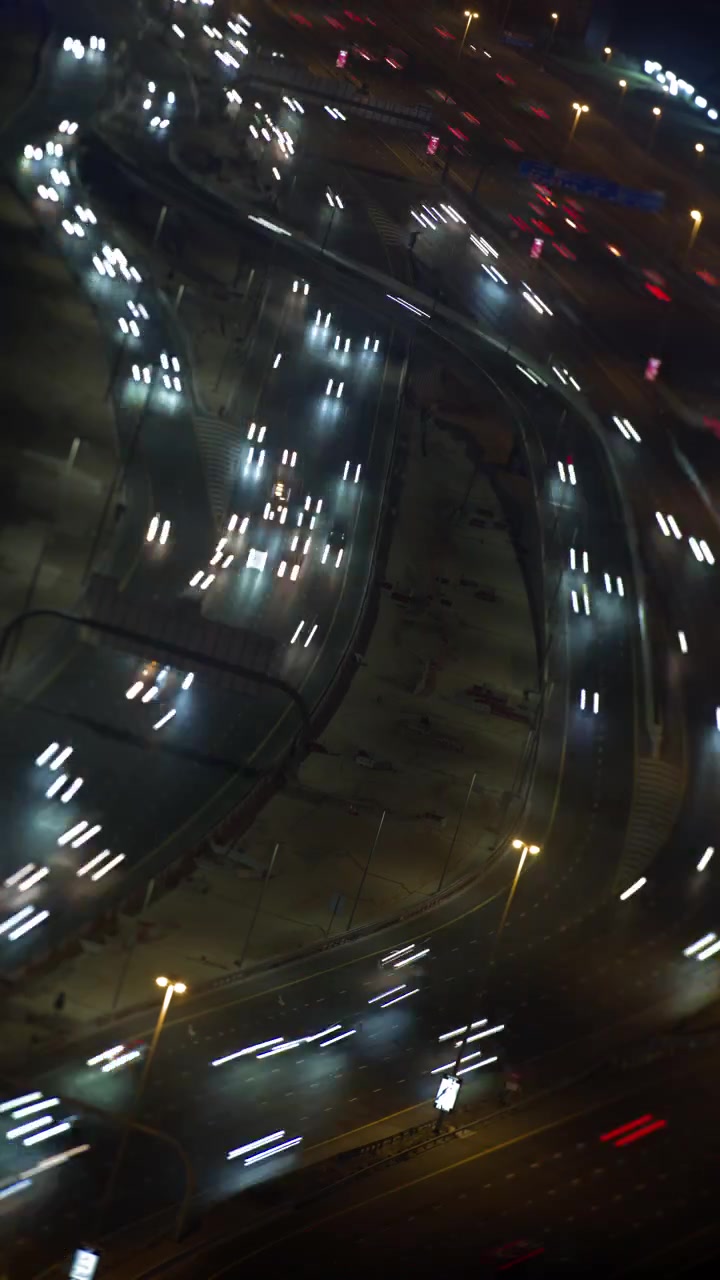 Time-lapse aereo del traffico notturno su svincolo autostradale urbano