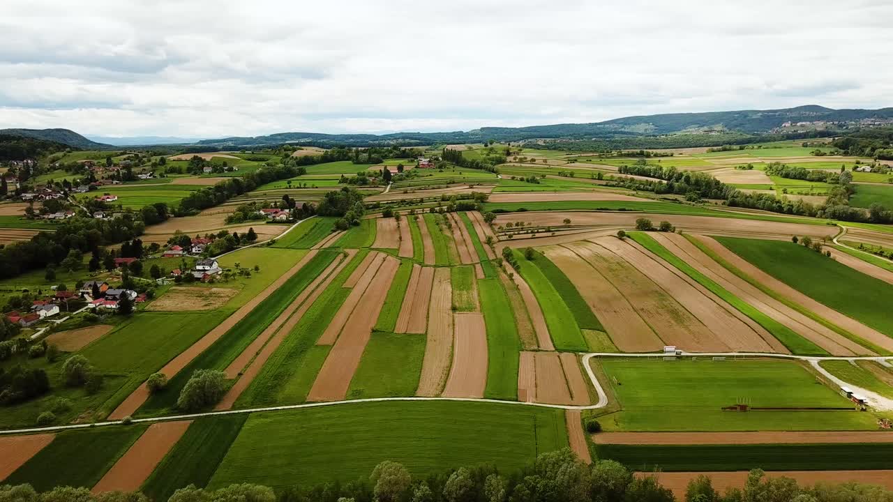paisaje aéreo tiro deslizante de la campiña eslovena con casas de colinas y campos agrícolas cielo nublado eslovenia europa
