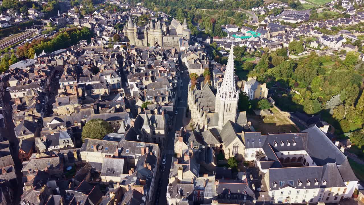 Aerial of Notre Dame Church in Vitre, France surrounded by historic rooftops and cityscape, panoramic establishing