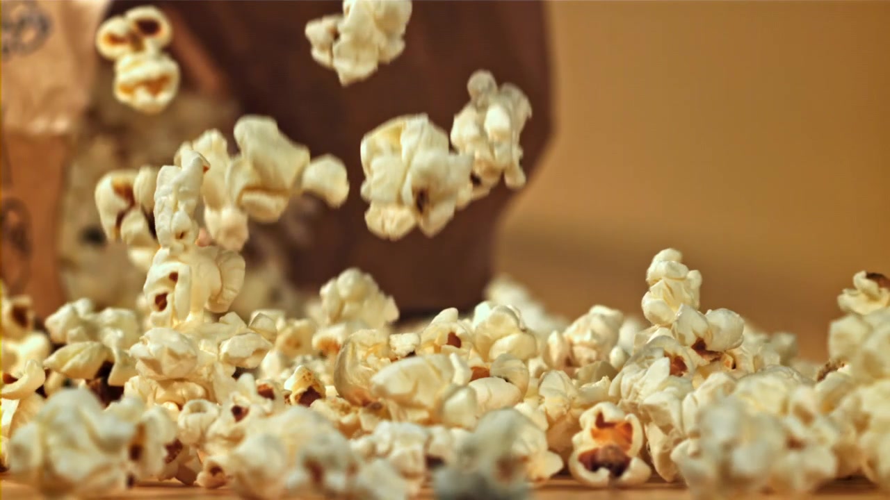 Popcorn freschi che cadono al rallentatore da un sacchetto di carta