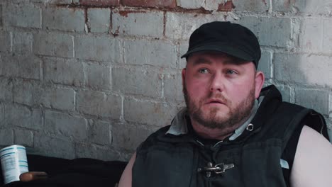 sad thoughtful homeless man siting in a cellar of and abandoned building