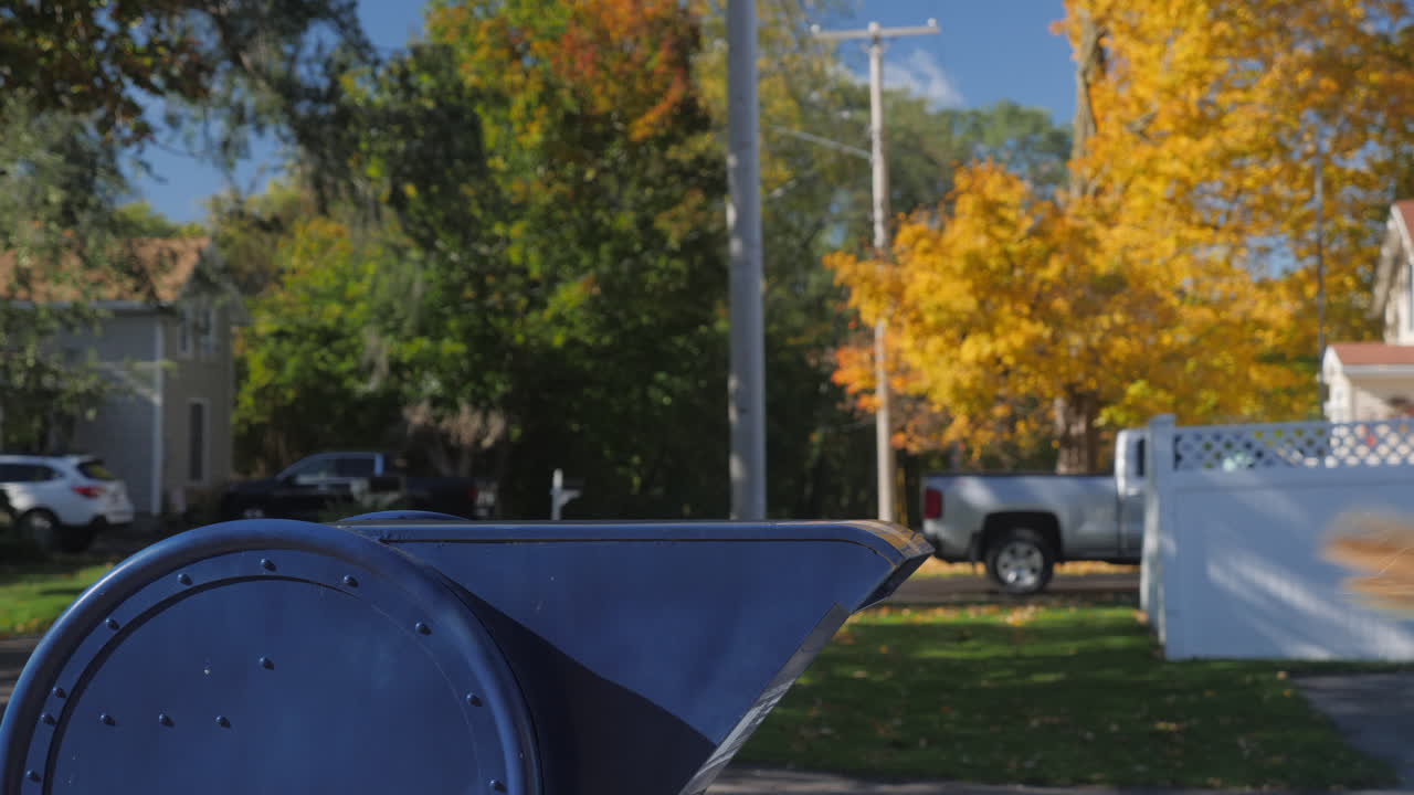 ребенок посылает письмо - бросает его в синий почтовый ящик на типичной американской улице