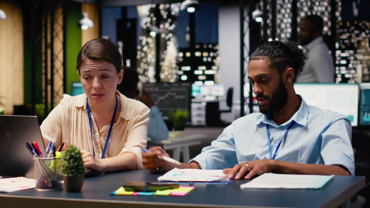 Middle Eastern man in wheelchair and woman CEO collaborating at night