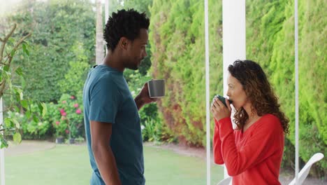 Feliz-Pareja-Birracial-Relajándose-Y-Tomando-Café-Juntos-En-El-Patio