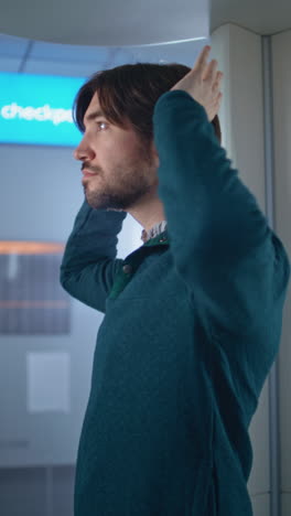 man adjusting his hair at the airport security