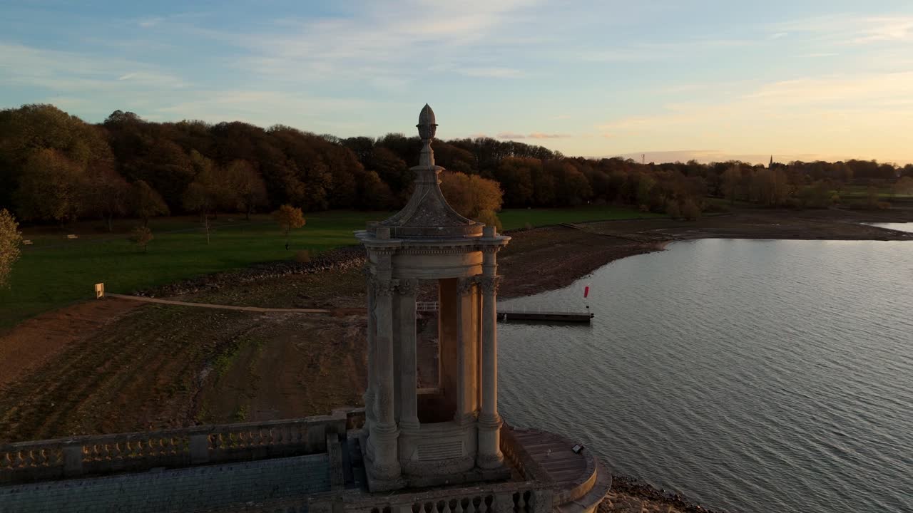Filmato aereo ad alta risoluzione realizzato con drone della chiesa di Normanton presso il bacino idrico di Rutland Water con luce invernale dorata, Regno Unito