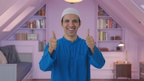 hombre musulmán feliz mostrando los pulgares hacia arriba