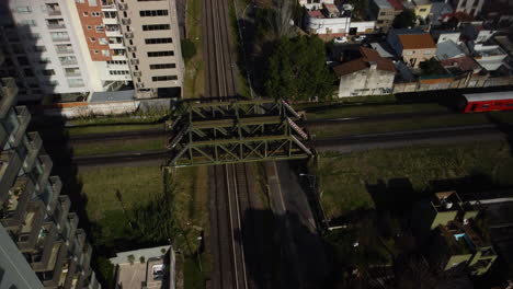 red train rides on the railway bridge, blue train rides on another railway road, buenos aires, summer, traffic, road crossing