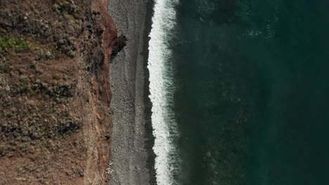 Aerial-of-spectacular-rocky-beach-and-cliffs-with-waves-breaking-on-shore
