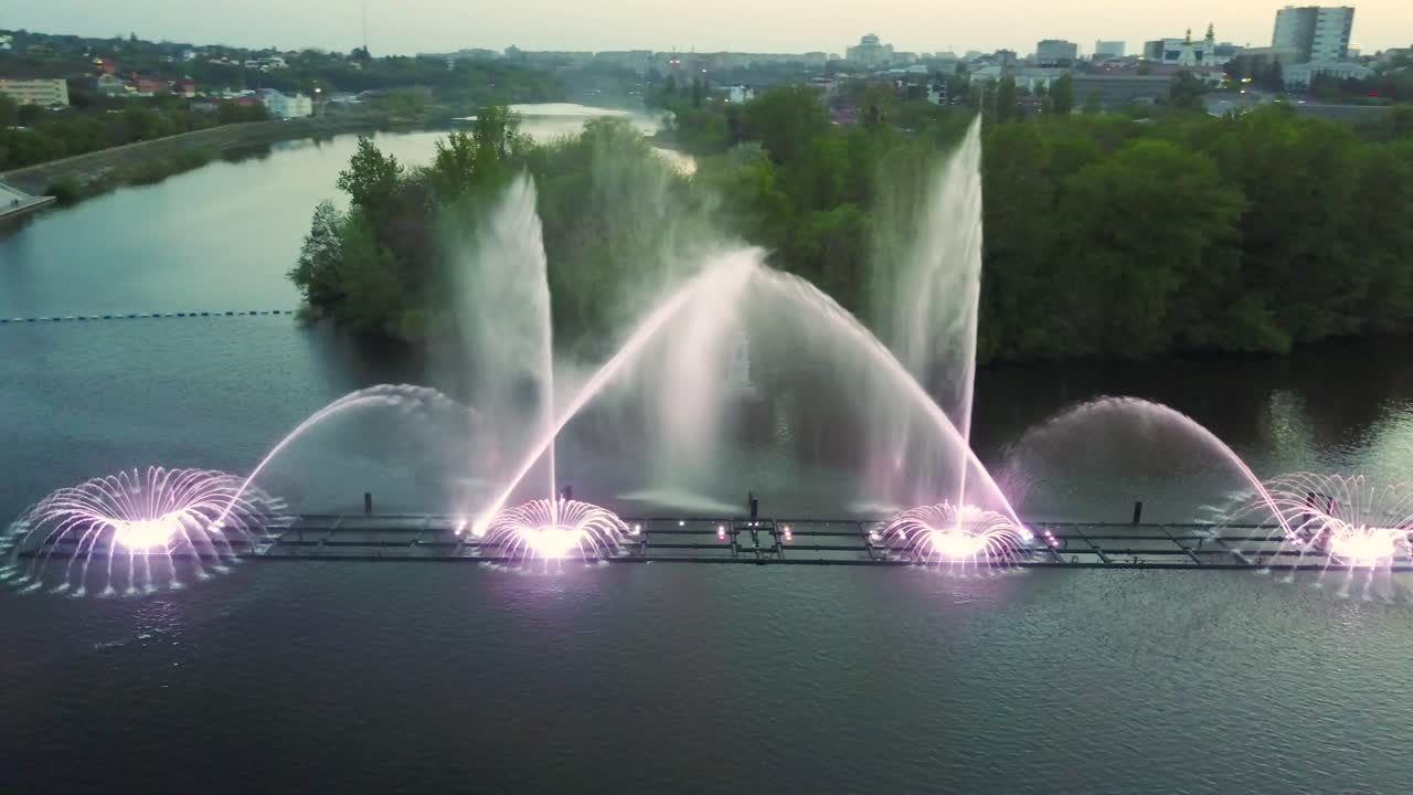 Fountain With Colorful Illuminations At Night. Aerial shot of the magic fountain - lights,colors and music spectacle at night