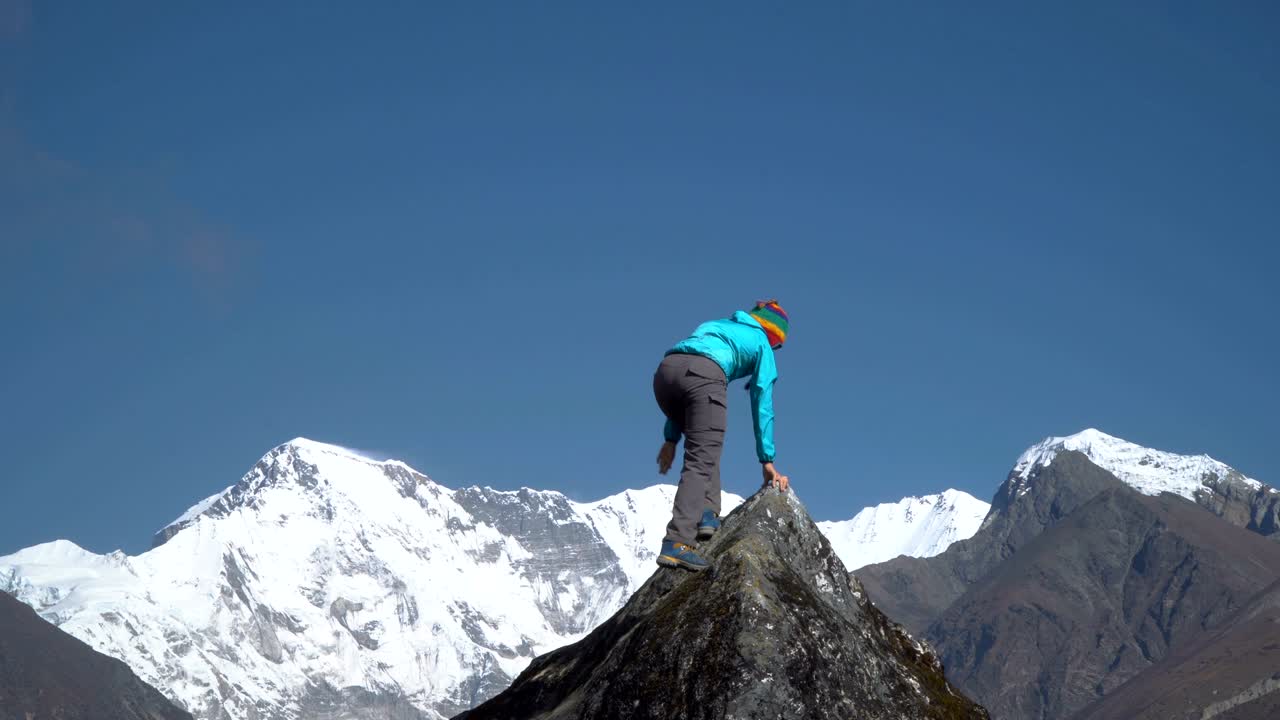 la chica sube a la cima del acantilado