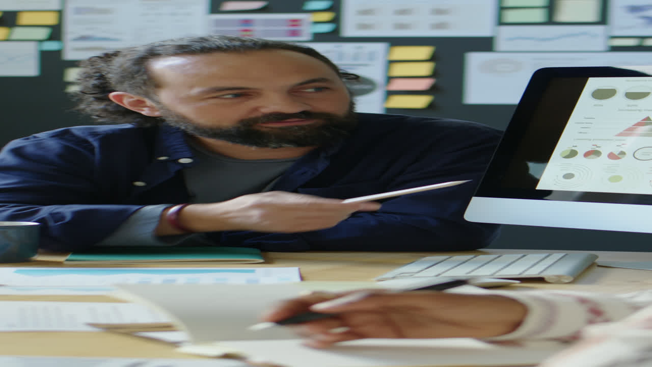 Businessman Discussing Presentation on Computer with Colleague
