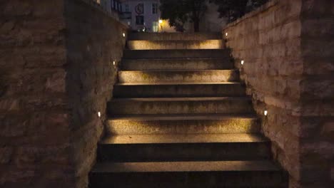 gorgeous staircase or stairs in tallinn old town in estonia capital city that is made of stone and well and dimly lit with led light during night time or dusk. good weather and medieval houses visible