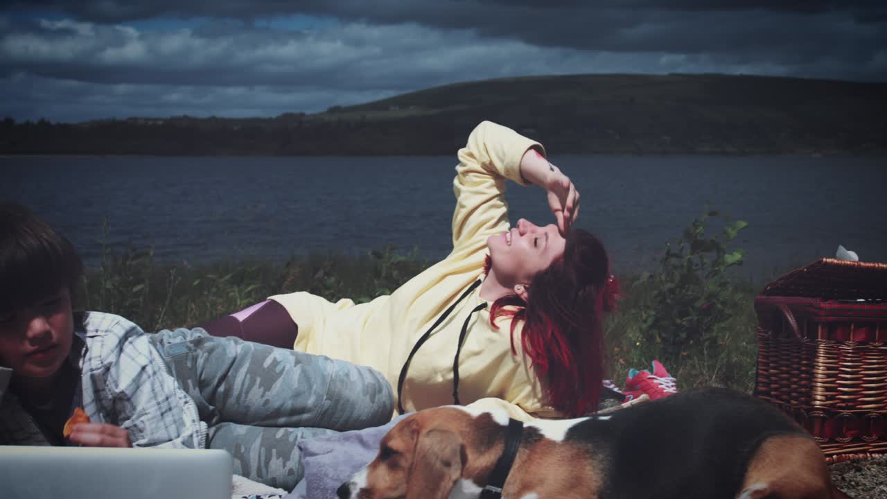 4k 엄마, 아들과 개가 해변에서 휴식을 취하고 있습니다.