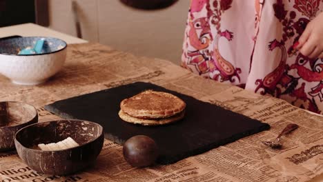 cook stacking pancakes on a plate preparing breakfast