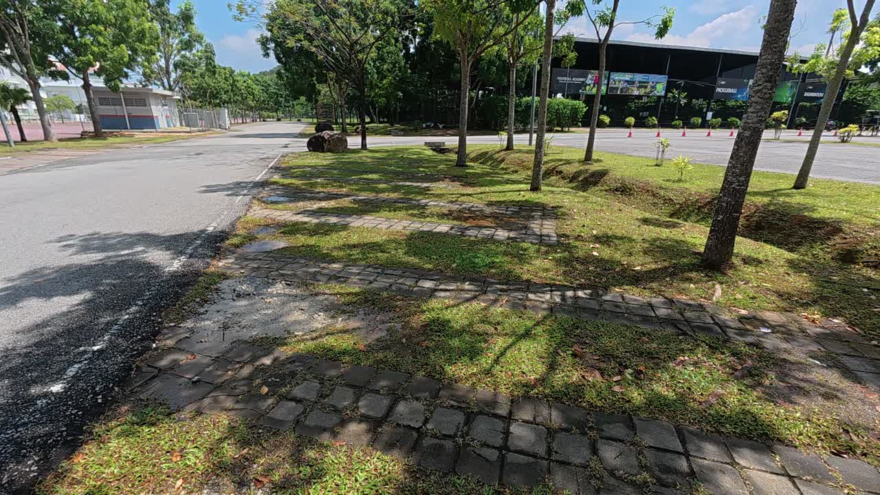 A car park features eco-friendly grass paver blocks. These porous concrete blocks allow grass to grow through the surface voids. This design promotes green infrastructure and sustainable paving