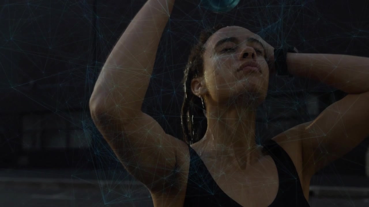 Woman raising green water bottle and pouring water over braided hair during dusk fitness refresh