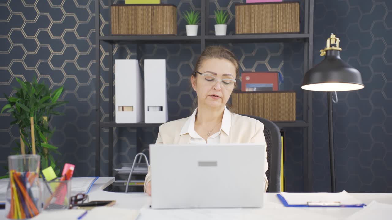 사업가 여성이 일에서 피곤한 카메라를 보고 있습니다.