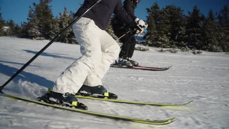 4k slow motion of female skier carving in the snow at high speed on a sunny winter day with blue sky in a ski resort in norway