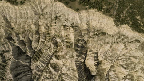 Arid-hills-and-ravine-in-eroded-terrain-next-to-bushy-steppe,-Georgia