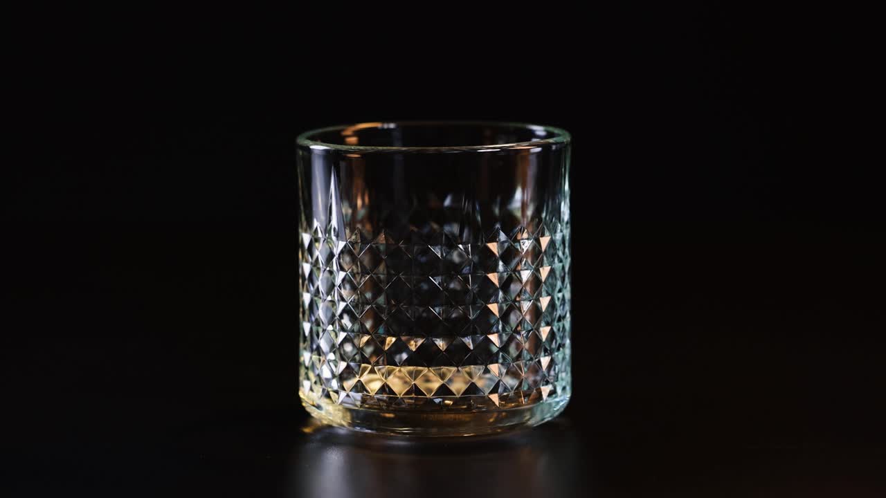 얼음 큐브가 유리 컵에 떨어집니다.