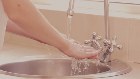 Woman-washing-her-hands-in-a-sink-