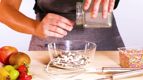 pouring chocolate chips into a mixing bowl