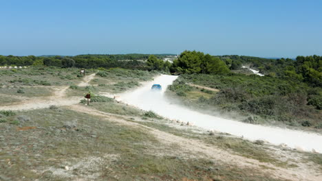 conducción de automóviles azules en una pista todoterreno polvorienta en el cabo kamenjak cerca de pula, croacia