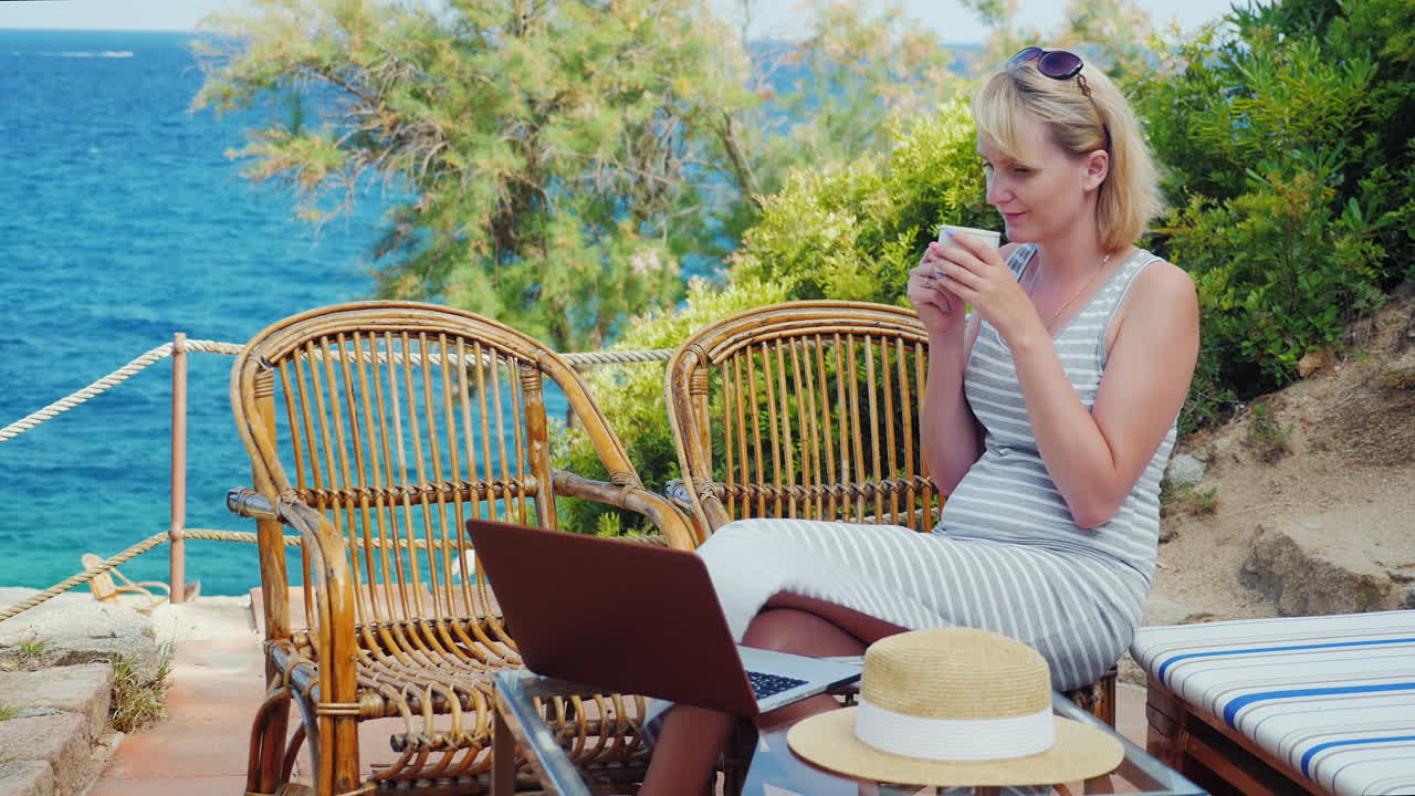 b에서 일하는 바다 전망 여성 프리랜서 앞에 노트북과 함께 테이블에 앉아 있는 젊은 여성