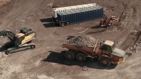 birds eye view of a dump truck full of dirt traveling a construction site