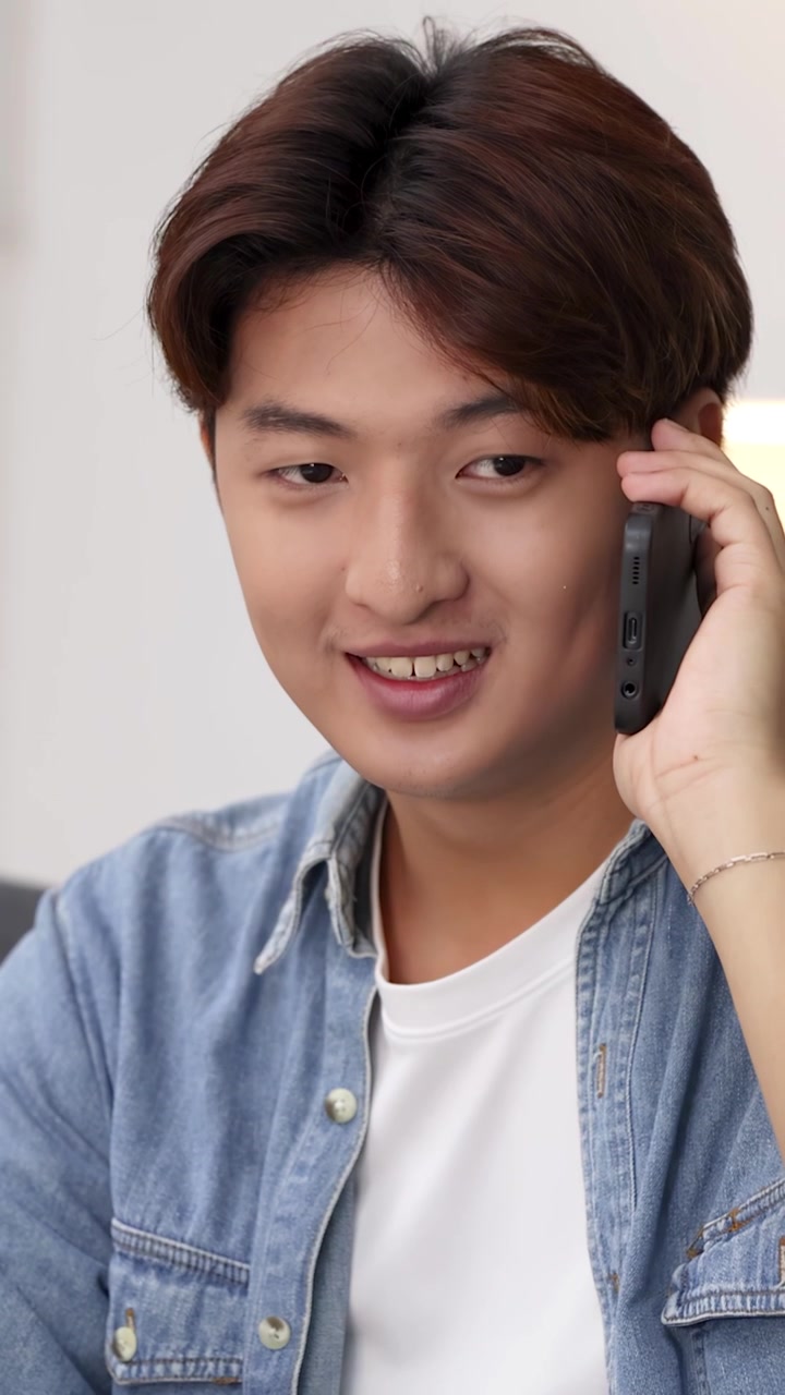 Giovane Uomo Asiatico Felice che Parla allo Smartphone