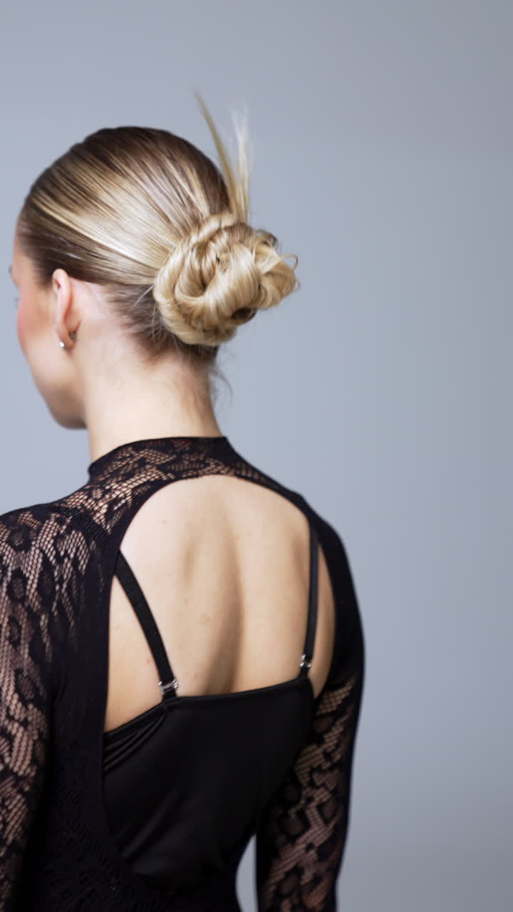 Beautiful Caucasian model wearing black long-sleeve bodysuit with snake print. Portrait of a blonde woman posing for camera. Vertical video.