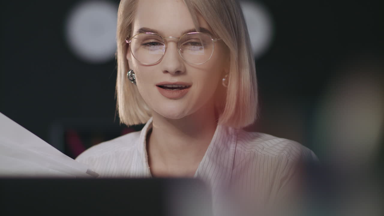 mujer de negocios satisfecha buscando documento financiero portátil frontal en la oficina nocturna