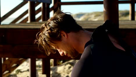 surfista masculino con traje de neopreno en la playa 4k