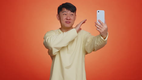 asian adult man traveler blogger taking selfie on smartphone, communicating video call online stream