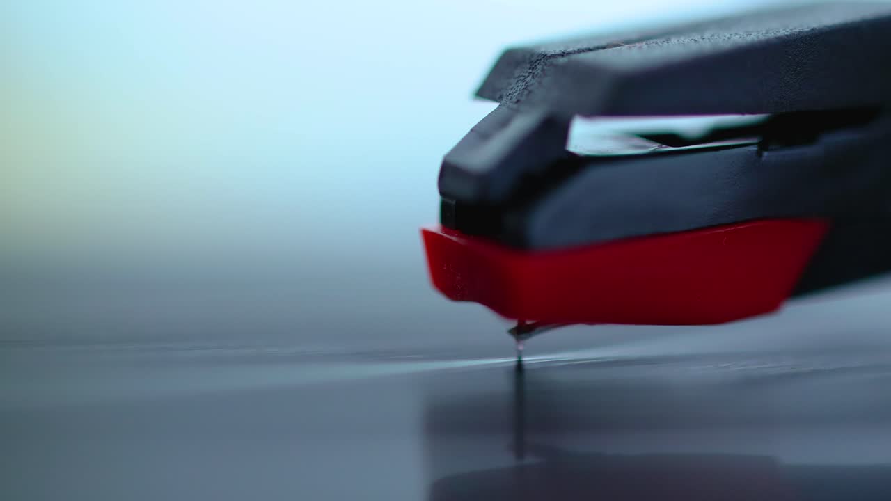 비닐을 긁는 축음기 바늘의 클로즈업 샷