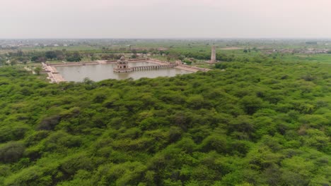 aerial flyover of forest surrounding travel destination hiran minar in pakistan