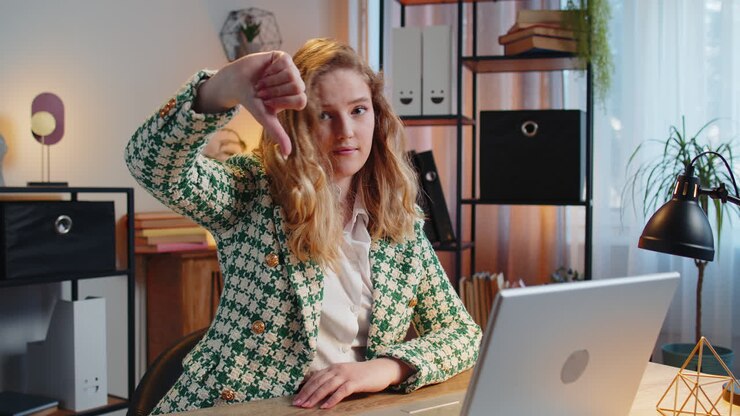 Oprørt forretningskvinde freelancer arbejder på bærbar computer viser tommelfingeren nedad tegn misbilligelse utilfreds