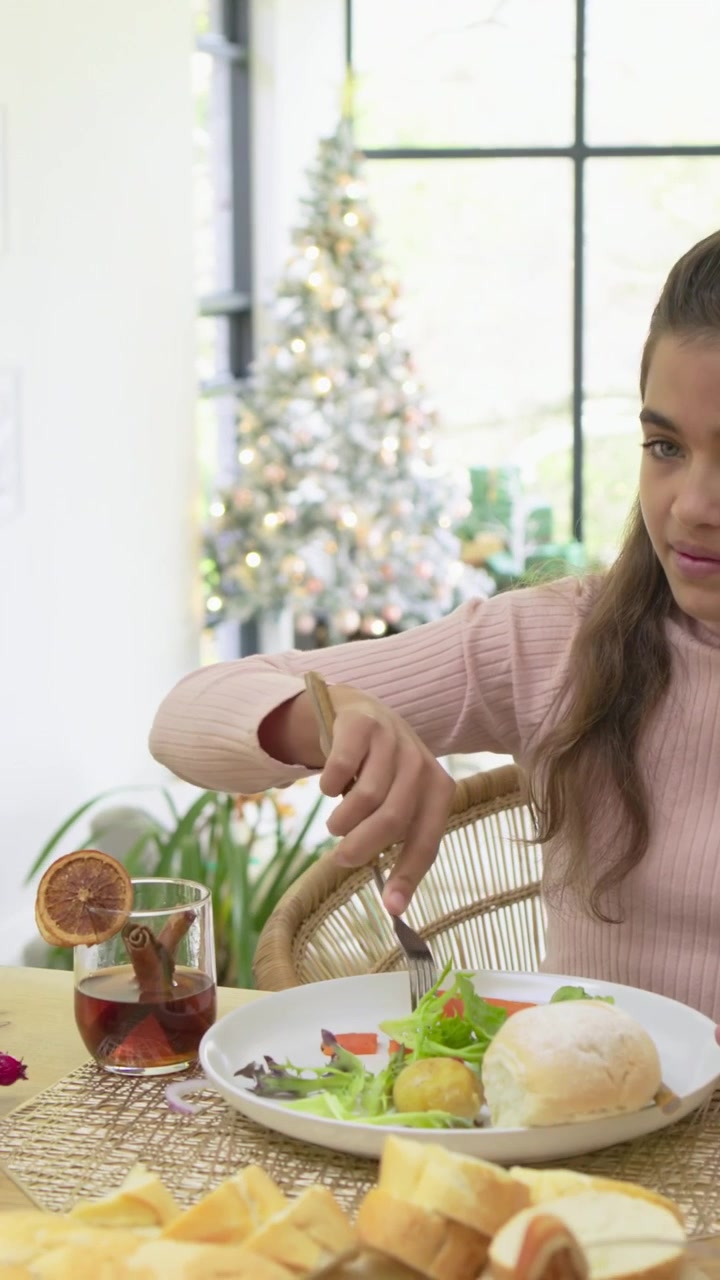 Vertical video: Adult handing glass, child pink top reaching, cutting food, preparing meal at home